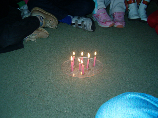 candele accese e bambini in cerchio
