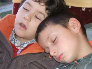 foto di bambini che stanchi si addormentano in pulman