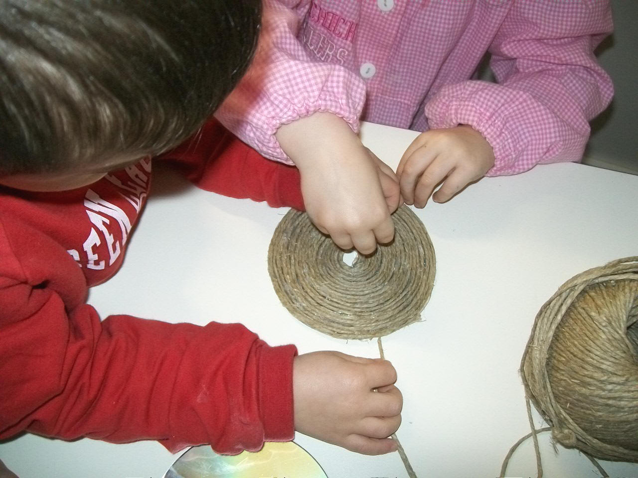 foto dei bambini che costruiscono la lumaca con il materiale di recupero