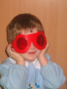 foto di un bambino con occhiali dalle lenti rosse