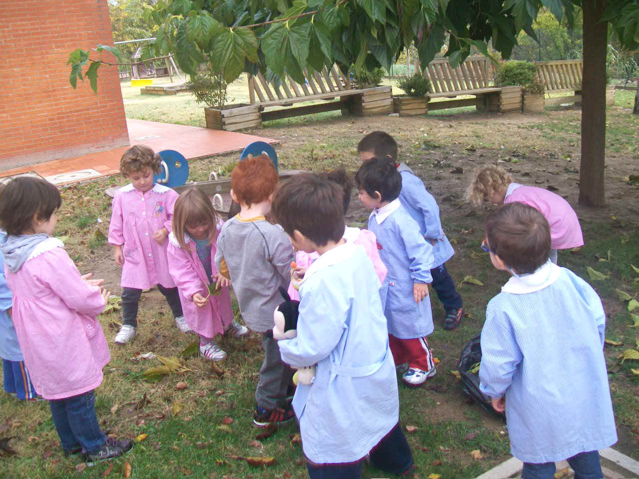 bambini che raccolgono le foglie dal giardino