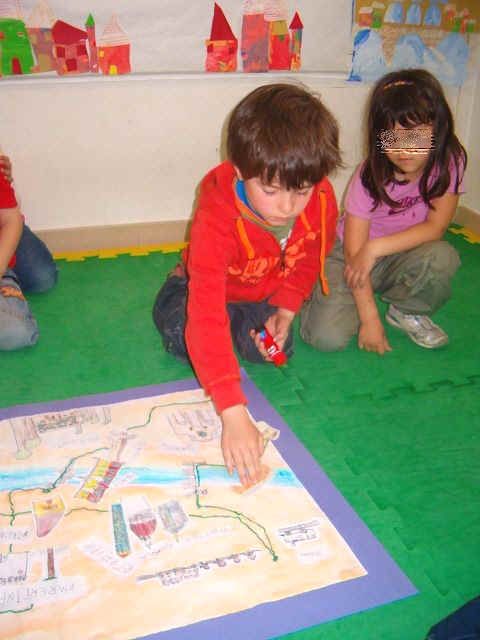 bambini che stanno costruiendo il cartellone della mappa