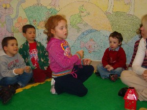 foto dei bambini in cerchio sul tappeto a discutere che gioco poter realizzare