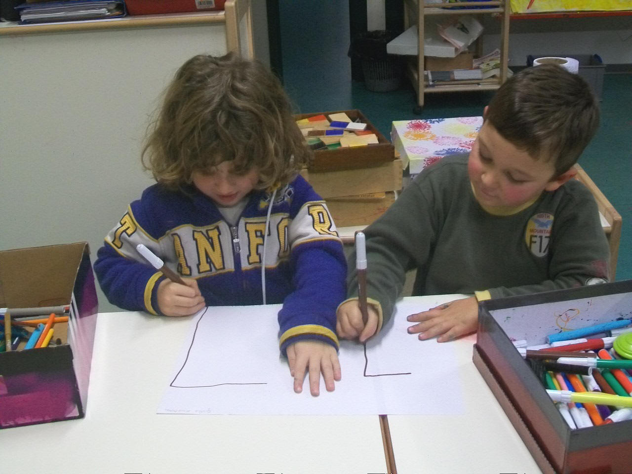 foto dei due bambini che disegniano la loro storia inventata