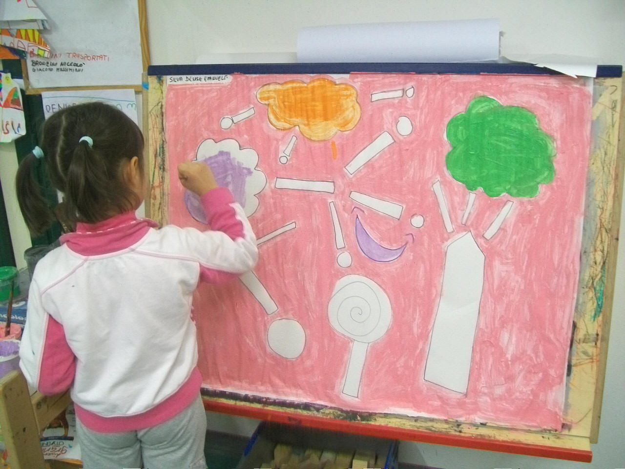 foto di bambini che pitturano un cartellone con i colori e le forme della felicit