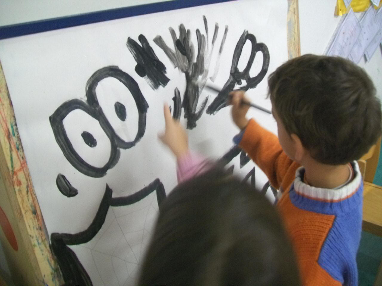 bambini mentre dipingono il cartellone con i colori e le forme della paura