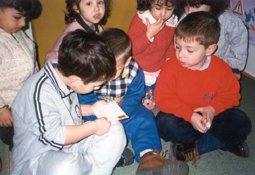 foto: bambini che discutono osservando una cartolina