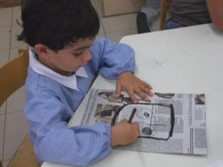 foto di bambini che disegnano con il carboncino su fogli di giornale