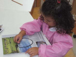 foto di bambini che disegnano con il carboncino su fogli di giornale