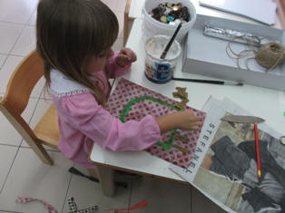 bambini che realizzano con materiale di recupero i volti creativi
