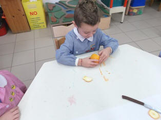 foto di bambini che smontano e osservano l'arancia