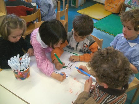 foto dei bambini che disegnano a gruppi le storie di primavera